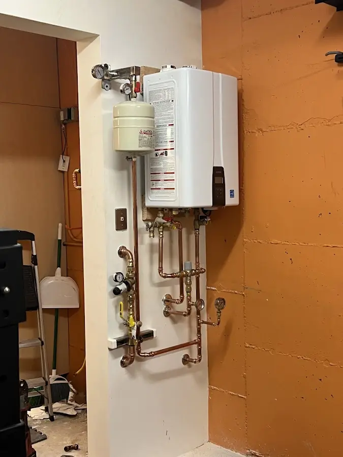 Plumbing technician inspecting water heater connections in Royal Pines